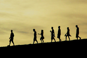 Silhuettes of people walking downhill